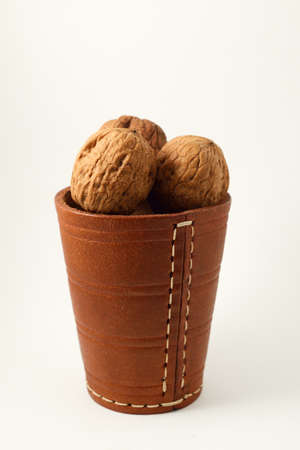 walnuts in a leather glass on a white backgroundの写真素材