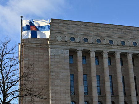 waving Finnish flag and Finnish parliament building on Finnish Independence Dayの写真素材