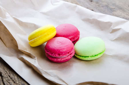 Colorful French macaroons and cup of tea on a dark rustic wooden background, selective focusの写真素材