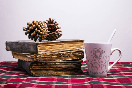 Cup of coffee and book on table with checkered tableclothの写真素材