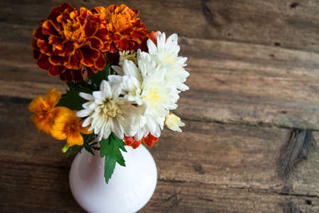 Beautiful autumnal flower bouquet on wooden tableの写真素材