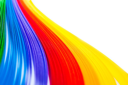 Rainbow colored quilling paper laid out in waves and shapesの写真素材