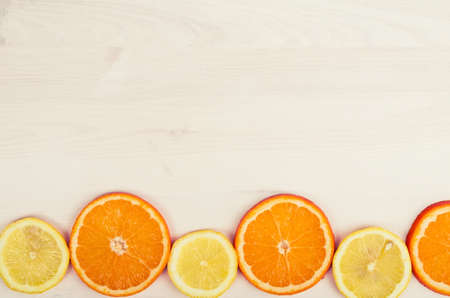 Fresh oranges and lemons on wooden backgroundの写真素材