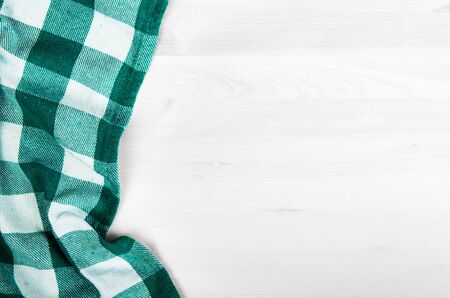 green folded tablecloth over bleached wooden table