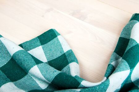 green folded tablecloth over bleached wooden table