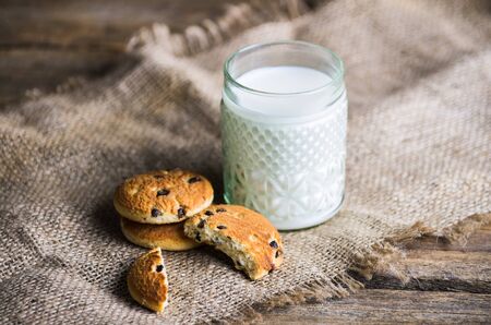 Tasty cookies and glass of milk on rustic wooden backgroundの写真素材