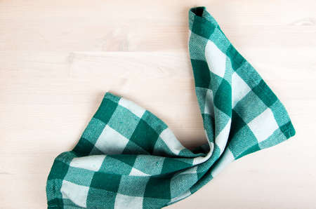 green folded tablecloth over bleached wooden tableの写真素材