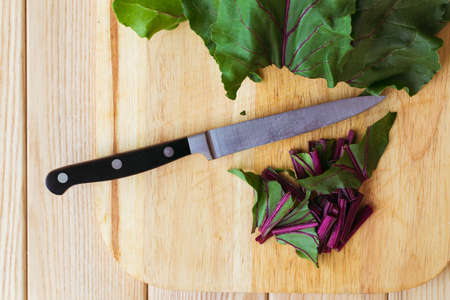 Bunch of red beet leaves on wooden backroundの写真素材