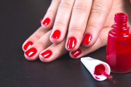 red manicure with nail on a black backgroundの写真素材
