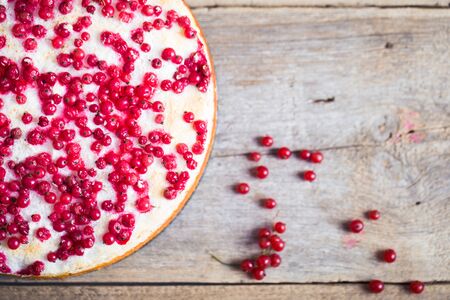 cheesecake with fresh red currants on a thin wooden backgroundの写真素材