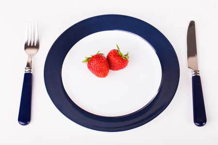 strawberries on a plate with knife and forkの写真素材