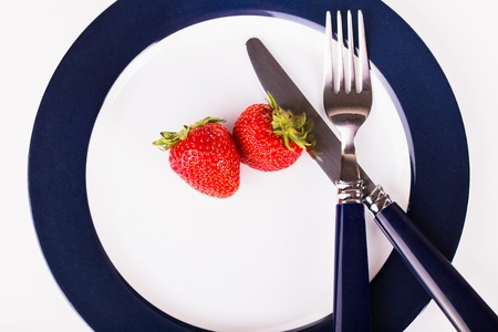 strawberries on a plate with knife and forkの写真素材