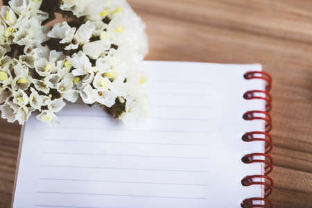flowers notebook and pencil on wooden backgroundの写真素材