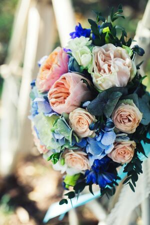 Wedding bouquet of bride - colorful flowers pink, white roses and blue freesia and hydrangea at wedding on natureの写真素材
