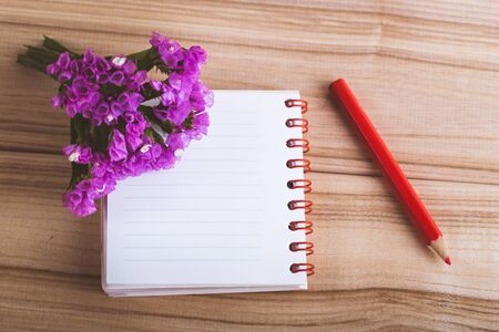 flowers notebook and pencil on wooden backgroundの写真素材