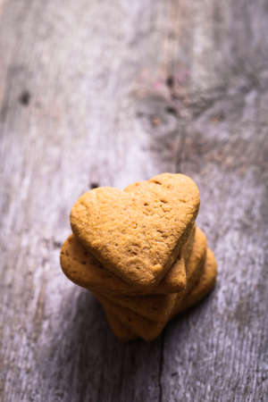 cookies in the shape of a heart on a wooden backgroundの写真素材