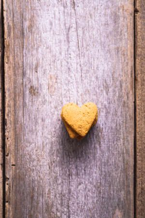 cookies in the shape of a heart on a wooden backgroundの写真素材