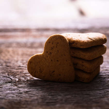 cookies in the shape of a heart on a wooden backgroundの写真素材