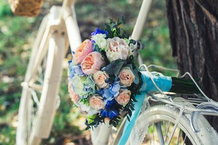 Wedding bouquet of bride - colorful flowers pink, white roses and blue freesia and hydrangea at wedding on natureの写真素材