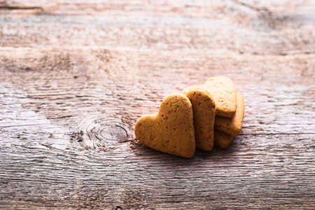 cookies in the shape of a heart on a wooden backgroundの写真素材