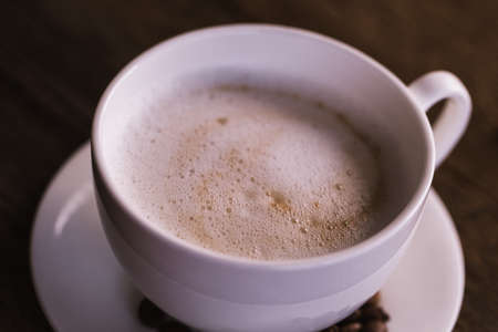 Ð¡up of coffee with beans on old wooden background