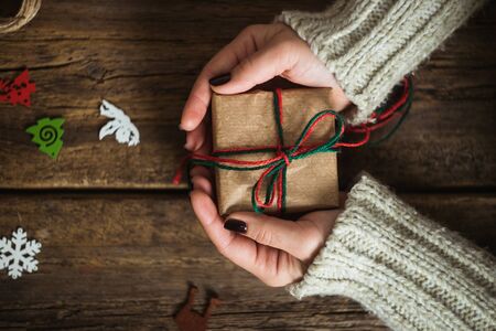 Male hands wrapping xmas gifts into paper and tying them up with red threadsの写真素材