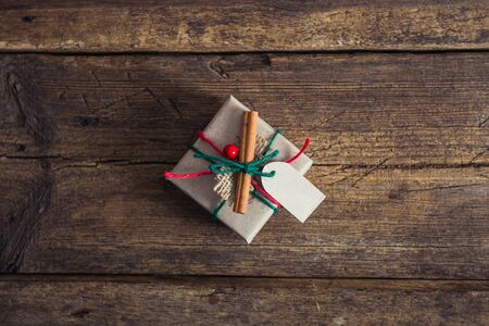 Christmas presents on a wooden background with candy cane, fir branches, candle, cones.の写真素材