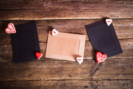 Gift Cards on wooden background with cookies in the shape of heart and red ribbonの写真素材