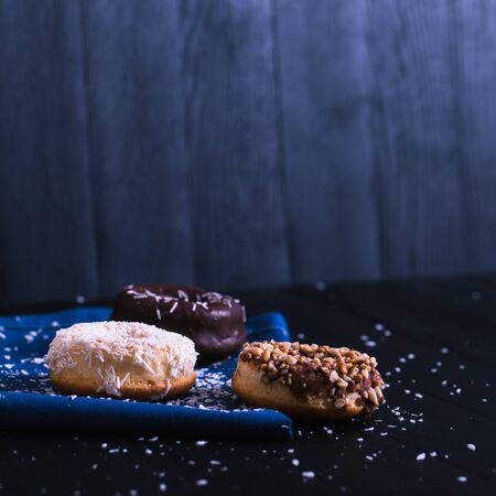 donuts with different powder on a black wooden background