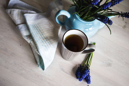 Blue flowers in a teapot with a cup of tea on wooden background. Vintageの写真素材