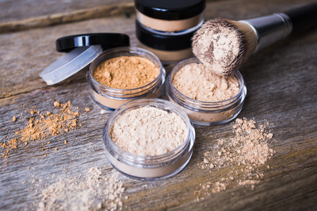 mineral powder of different colors with a brush for make-up on wooden backgroundの写真素材