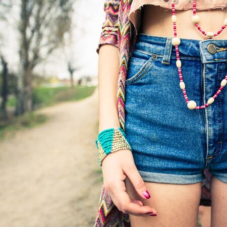young girl in denim shorts, jewelry accessories.