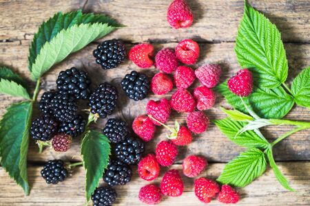 Blackberries and raspberries on wooden background. Natureの写真素材