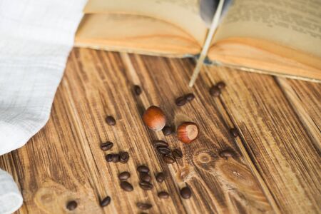 hazelnut coffee beans and book on wooden backgroundの写真素材