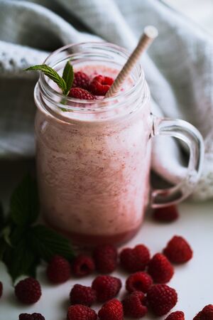 Pink raspberry smoothie in a mason jar with strawsの写真素材