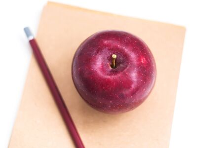 Apple, pencil and notebook on isolated white background