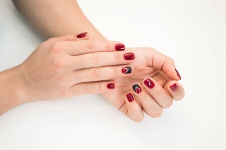 Closeup photo of a beautiful female hands with red nails on white background