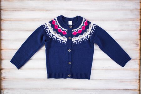 Stylish blue sweater on a children's wooden background