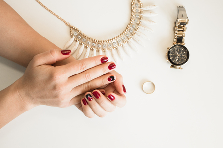 Closeup photo of a beautiful female hands with red nails on white backgroundの写真素材