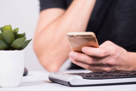 Hands of businessman using a mobile phone and keyboardの写真素材