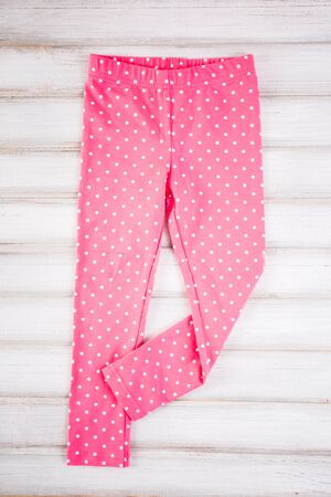 Stylish baby pink pants on the wooden backgroundの写真素材
