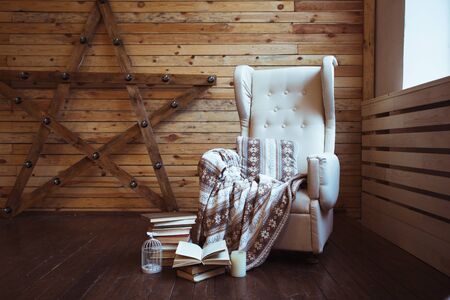 Stack of books with warm plaid on chairの写真素材