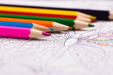 Multi-colored pencils and coloring book for adultsの写真素材