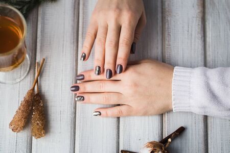 Woman holding a cup of tea above the wooden table.の写真素材