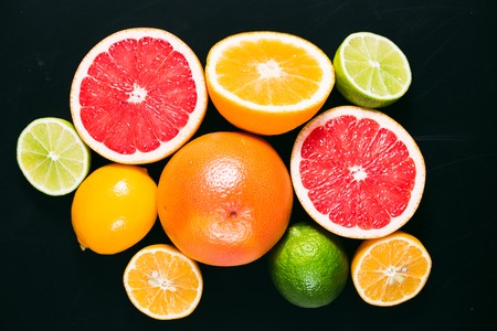 Fresh citrus stihli. Lemons, limes, grapefruit and orange on a black backgroundの写真素材