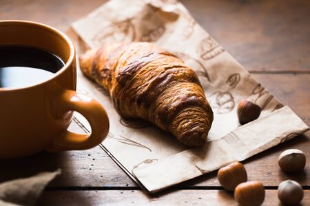 Coffee croissant on old wooden table backgroundの写真素材