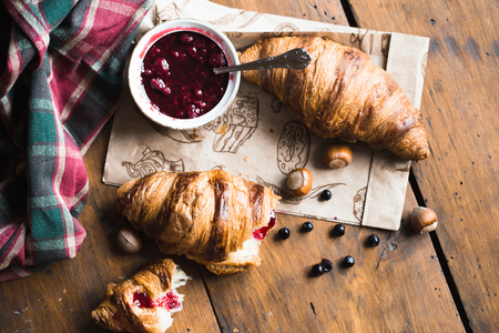 Tasty buttery croissants on old wooden table.の写真素材