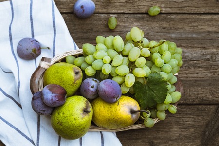 fruit grapes plum pear on wooden backgroundの写真素材