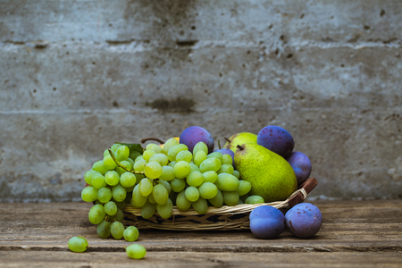 fruit grapes plum pear on wooden backgroundの写真素材
