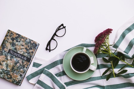 Notepad and cup of coffee on white background.の写真素材